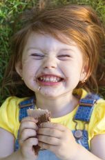 Kinderfotos_5_Tipps Lachendes Kind liegend im Gras