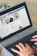 Facebook Stories Userin surft auf einem Laptop durch Facebook