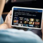 Ein Mann betrachtet das kostenlosen Amazon Prime Freevee Streaming-Angebot auf seinem Tablet.