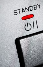 Der Einschaltknopf eines Elektrogeräts mit dem Schriftzug Standby und einer rot leuchtenden Anzeige dazu.