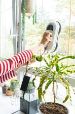 Frühjahrsputz, So wird dein Zuhause sauber Eine Person reinigt mit einem elektrischen Fenstersauger ein Fenster in ihrem Zuhause.
