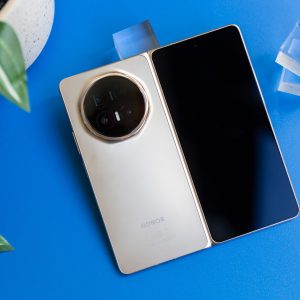 Ein Honor Magic V6 liegt auf einem blauen Regal. Das Foldable ist aufgeklappt, mit dem Innendisplay nach unten.